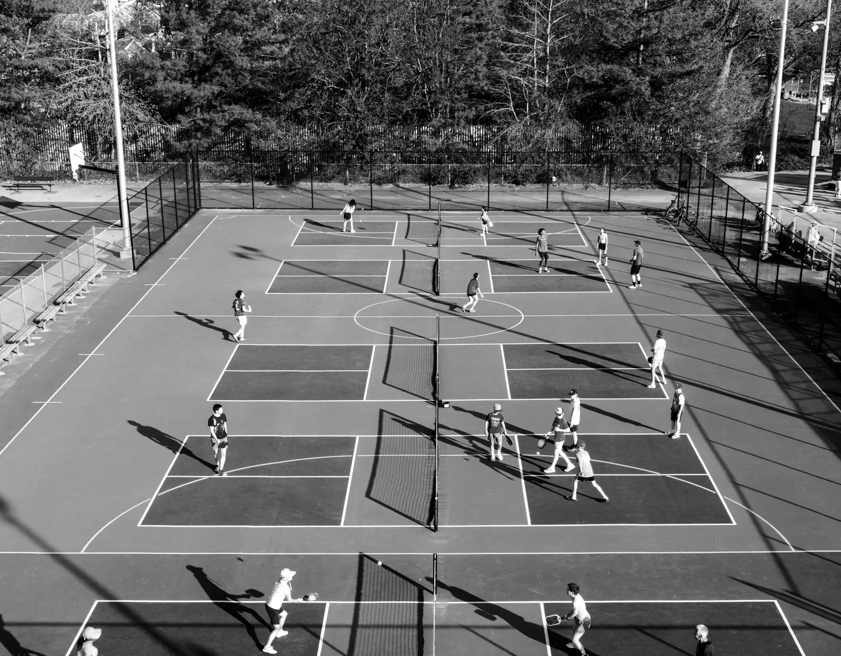 An aerial view of outdoor pickleball courts full of doubles games